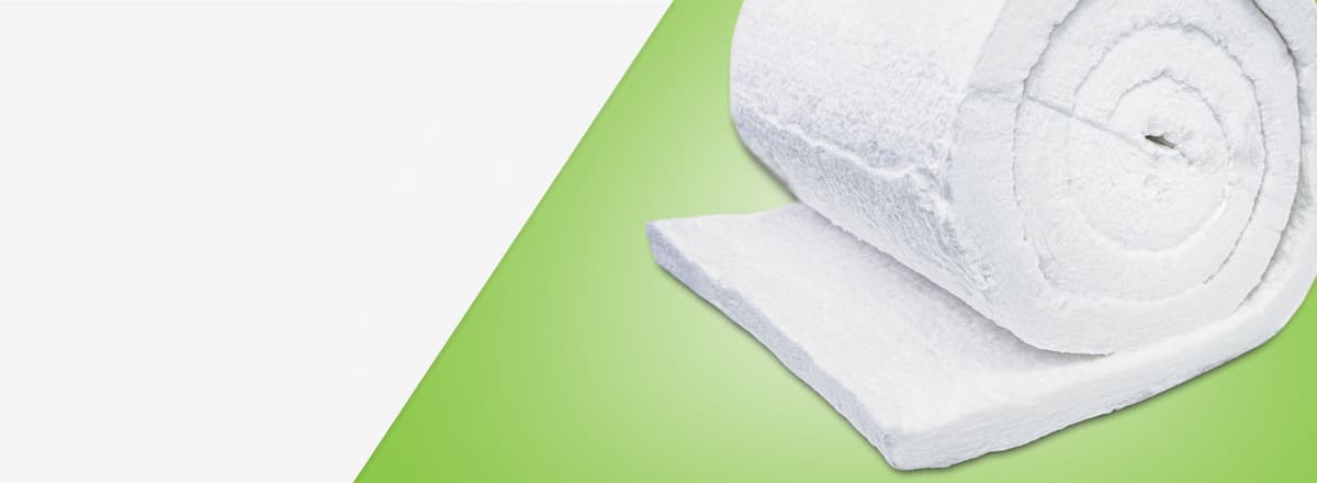 Um rolo de manta de isolamento térmico branca, com textura fibrosa, parcialmente desenrolado sobre um fundo verde.