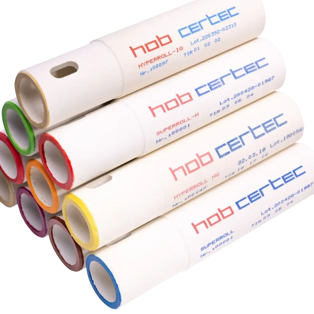 A stack of white cylindrical ceramic rollers with brand labels and colored rings at the ends.
